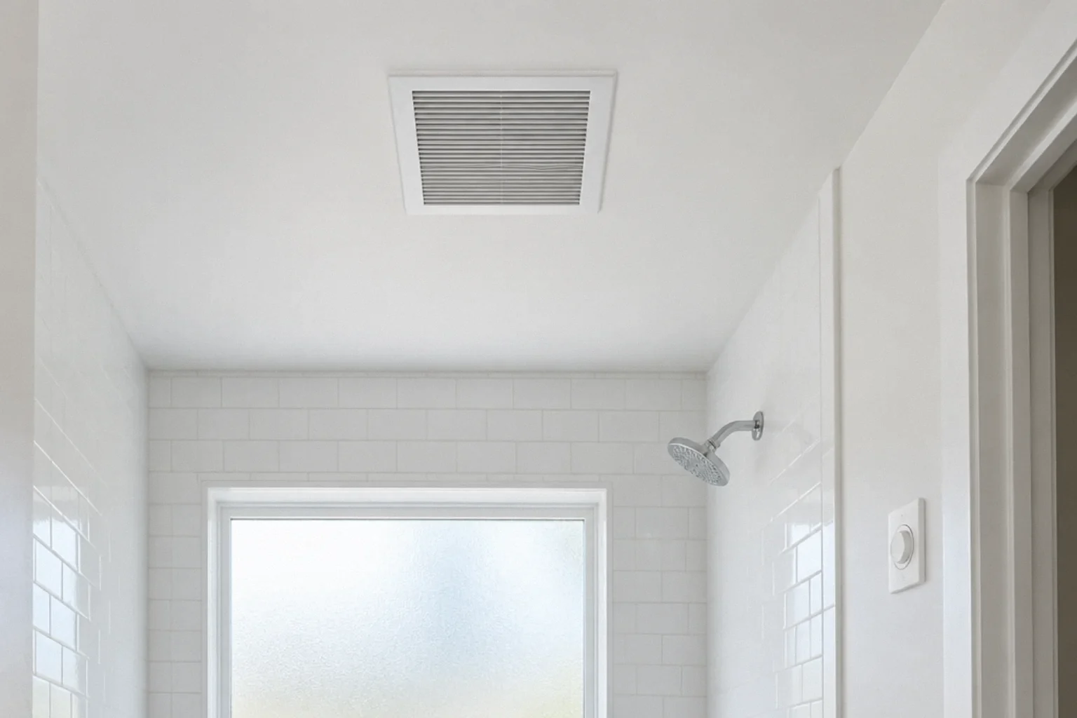 Ceiling-mounted bathroom exhaust grille and wall control beside a tiled shower.